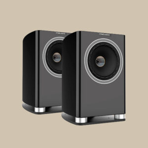 Ett par snygga svarta Fyne Audio F700-högtalare med runda element och coola metalldetaljer, redo att jamma på en beige scen.