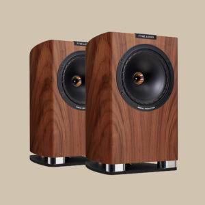 Snygga Fyne Audio F701SP-högtalare med rik valnötsfinish och svarta högtalarelement, redo att leverera rent ljud, placerade på beige.