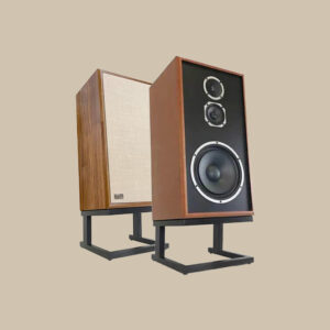 Ett par KLH Model Five-klassiker på eleganta stativ - den ena med trippelelement och den andra med ett vintage-beige galler - redo att fylla alla rum med fylligt ljud.