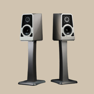 Slanka metalliska TuneTot-högtalare, woofers och tweeters, står redo att fylla det beigefärgade utrymmet med ren ljudglädje.