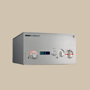 En elegant silverfärgad Nagra Classic-förstärkare, glödande digital display, taktila rattar och analog VU-mätare - ren ljudglädje på beige bakgrund.