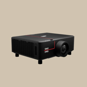 En elegant svart Ultranero 4-projektor med röda beats-inspirerade accenter, som framhäver dess lins och ventilationsöppningar på en kall beige scen.
