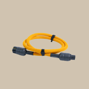 En gul flätad kabel med svarta kontakter i båda ändar, slingrad som ett perfekt ackord och fastspänd, vilar på en beige scen.