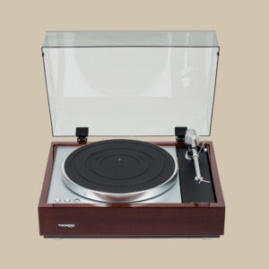 Thorens TD-1600 skivspelare bländar med sin klassiska träbas, öppna dammskydd och eleganta arm som väntar bredvid en svart tallrik.