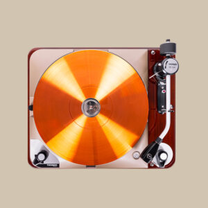 En fantastisk TD-124 DD 140th Ann skivspelare snurrar en livfull orange vinyl, och dess eleganta tonarm är redo att släppa nålen med stil.