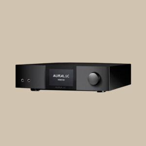 Auralic Vega G2, en elegant svart förstärkare med en livfull display, dubbla hörlursuttag och en stor kontrollratt, placerad på beige.