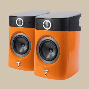 De eleganta orangea Focal Sopra No1-högtalarna med svarta toppar och runda element med silverlogotyp sticker ut mot en beige bakgrund.