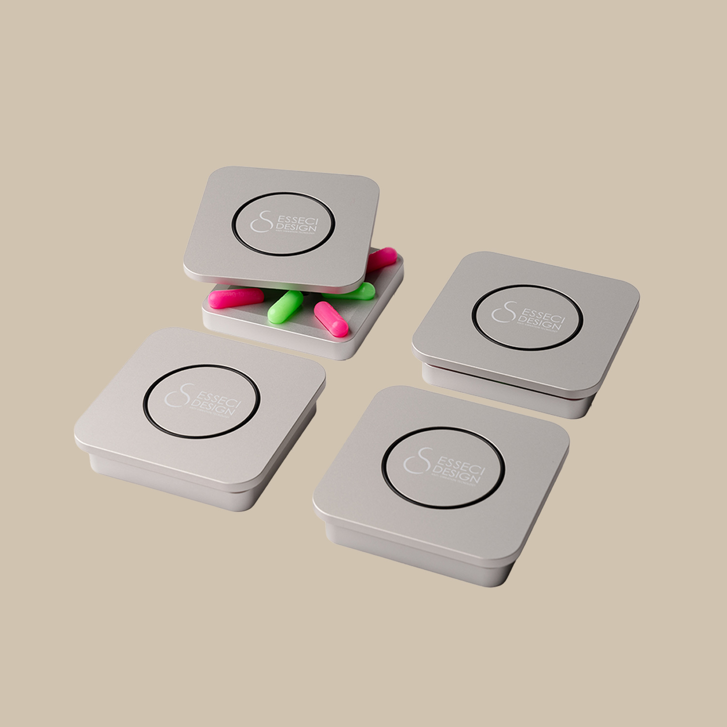 Fyra släta silverburkar med "Isol Coupling 8"-logotyper samsas som en kvartett; en öppnas och avslöjar livfulla gröna och rosa kapslar inuti.