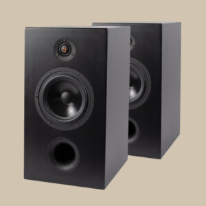 Två svarta Thivan S3-högtalare sitter sida vid sida, med woofers och tweeters redo att leverera ett fylligt ljud mot en beige bakgrund.