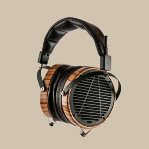 Audeze LCD-3, äkta audiofilpärlor med öronkåpor i trä och snygga svarta detaljer, vilar inbjudande på en beige bakgrund.