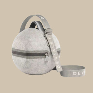 Mania Cocoon är ett runt, ljusgrått filtfodral som liknar ett vinylfodral - dragkedja i mitten, avtagbar rem, "DEVIALET" i fet vit färg.