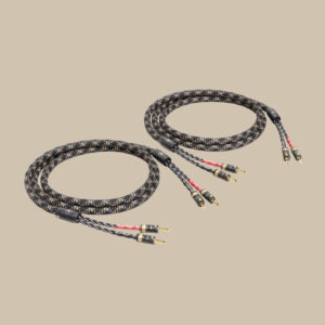 SC-4 Single-Wire T8 ljudkablar i elegant svart och vitt, guldpläterade banankontakter som glittrar, loopade på en beige scen.