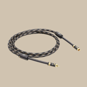 NF-75 T8 SPDIF, en vackert flätad ljudkabel med guldpläterade RCA-ändar, vilar upprullad på en mjukt beige bakgrund.
