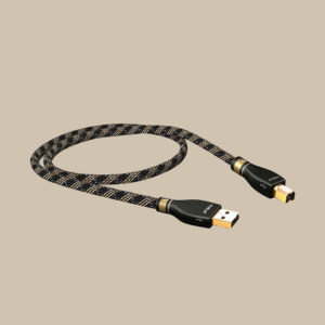 Den flätade USB A/B-kabeln KR-2 T6S, med guldpläterade kontakter, ligger upprullad som en diskantnyckel på en mjukt beige scen.