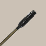 En fantastisk Wireworld Gold Eclipse XLR 4m-kabel med elegant svart och guldflätning och en djärv kontakt, placerad på beige.